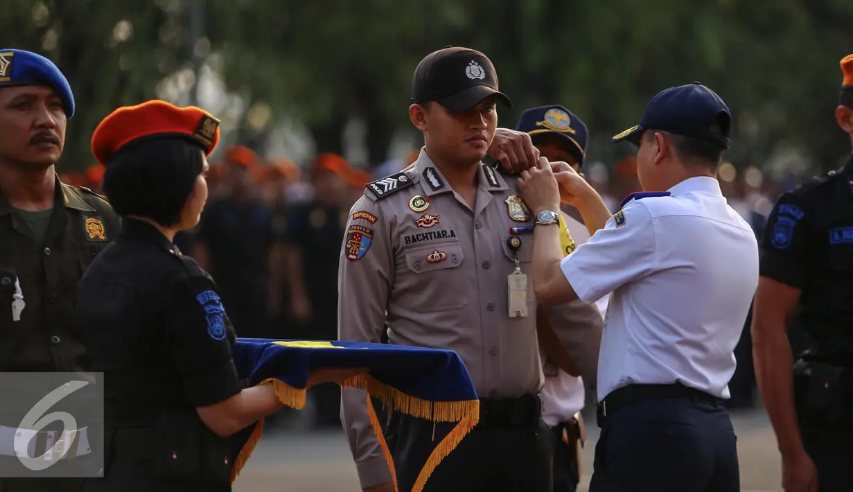 Ignasius Jonan memakaikan tanda di lengan secara simbolis saat apel siaga arus mudik Lebaran 2015, Jakarta, Kamis (2/7/2015). Jonan mengingatkan otoritas yang bertugas agar memberikan pelayanan terbaik kepada para pemudik. (Liputan6.com/Faizal Fanani)