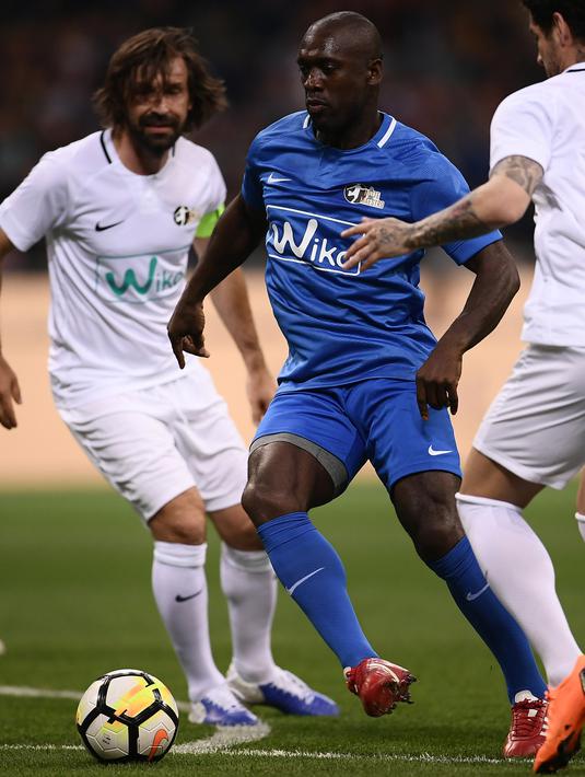 Legenda sepak bola Belanda, Clarence Seedorf (tengah) membawa bola saat mengikuti pertandingan perpisahan Andrea Pirlo, di Stadion Milan San Siro, Italia, (21/5). (AFP Photo / Marco Bertorello)