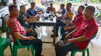 Personel Polres Rokan Hulu berdiskusi dengan simpatisan pasangan calon dan mengajak menjaga keamanan setelah pemungutan suara Pilkada 2024. (Liputan6.com/M Syukur)