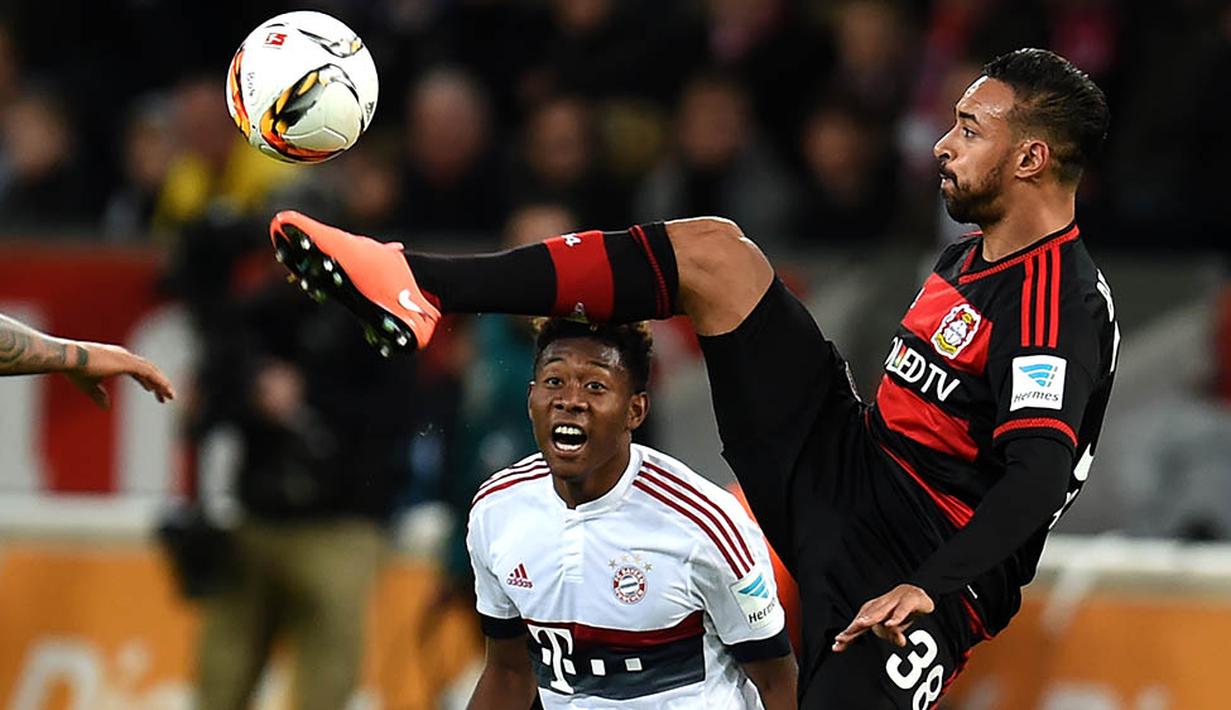 Gelandang Leverkusen, Karim Bellarabi, berusaha melewati bek sayap Bayern Munchen, David Alaba. Meski imbang, hasil ini tidak menggoyahkan Munchen di puncak klasemen Bundesliga. (AFP/Patrik Stollarz)