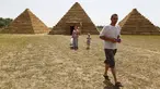 Wisatawan berjalan di sekitar replika Piramida Giza yang terbuat dari jerami di permukiman Krasnoye, Rusia, Rabu (19/7). Piramida unik itu salah satu bangunan yang menghiasi taman jerami di wilayah pertanian Ponomaryovo. (REUTERS/Eduard Korniyenkov)