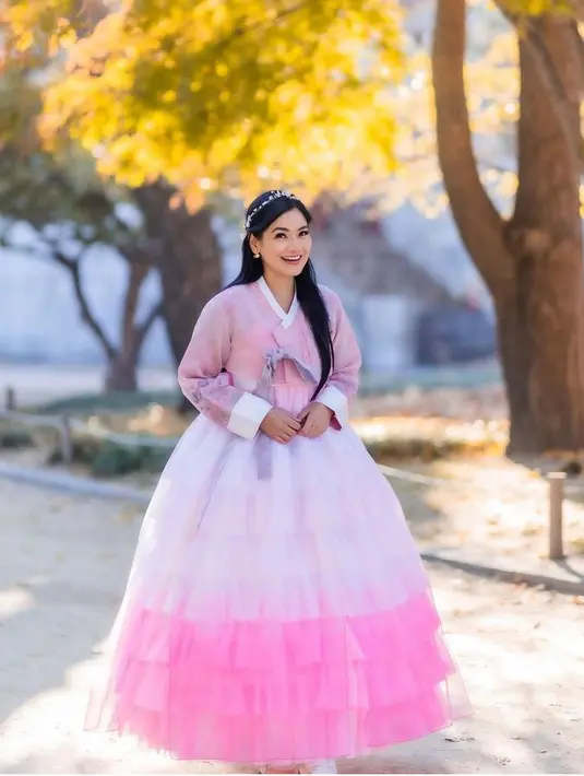 Titi Kamal beserta sang ibu liburan ke Korea Selatan, ia pun mencoba mengenakan hanbok pink dengan hiasan kepalanya. [@titi_kamall]