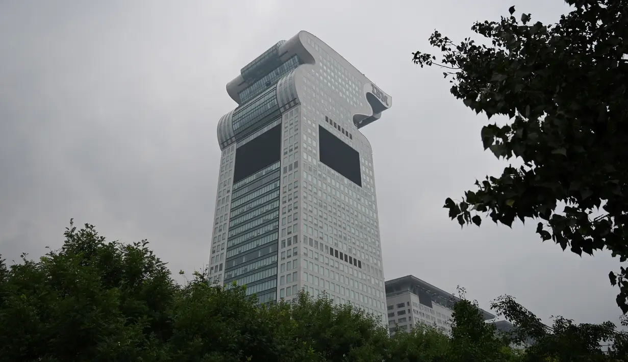 Gedung pencakar langit Pangu Plaza yang mendominasi daerah di seberang Stadion Olimpiade Bird's Nest, pusat kota Beijing, Selasa (20/7/2019). Bangunan 40 lantai hasil sitaan terkait kasus korupsi itu terjual dalam lelang online dengan harga 734 juta USD atau sekitar Rp10,5 triliun. (GREG BAKER/AFP)