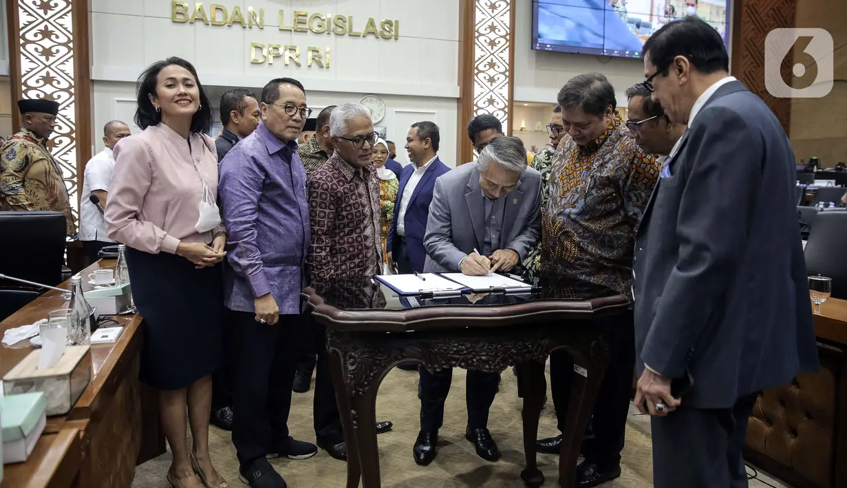 Wakil Ketua Baleg DPR M. Nurdin bersama Menko Perekonomian Airlangga Hartarto disaksikan Menko Polhukam Mahfud MD, dan Menkumham Yasonna Laoly menandatangani draft Peraturan Pemerintah Pengganti Undang-Undang (Perppu) Cipta Kerja di Kompleks Parlemen, Senayan, Jakarta, Rabu (15/2/2023). Baleg DPR menyetujui untuk membawa Perppu Cipta Keria ke Paripurna dan disahkan menjadi Undang-Undang (UU). (Liputan6.com/Faizal Fanani)