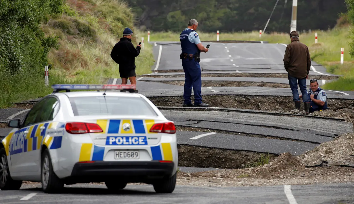 Polisi dan warga setempat melihat jalan retak di sepanjang State Highway One, sebelah selatan Blenheim di Pulau Selatan, Selandia Baru, Senin (14/11). Gempa 7,8 SR yang mengguncang Selandia Baru mengakibatkan jalan tersebut retak. (REUTERS/Anthony Phelps)