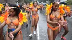 Penari karnaval menari di tengah hujan selama parade hari pertama Karnaval Notting Hill di London barat, Minggu (26/8). Karnaval Notting Hill yang merupakan pawai jalanan terbesar di Eropa diadakan setiap tahun sejak tahun 1966. (AFP/Daniel LEAL-OLIVAS)