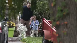 Joshua Boyle bersama anaknya Jonah bermain di kebun di rumah orang tuanya di Smiths Falls, Ontario (14/10). Boyle bersama istri dan ketiga anaknya dibebaskan oleh pasukan Pakistan dari tangan Taliban. (Lars Hagberg/The Canadian Press via AP)