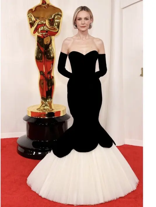 Mengambil inspirasi dari karakter yang dia mainkan di Maestro, Carey Mulligan memiliki tampilan dari koleksi Cristóbal Balenciaga tahun 1951 yang dibuat ulang untuk Oscar. Gaun hitam tanpa tali menampilkan siluet jam pasir yang mencolok dan keliman ekor ikan tulle putih. Dia memasangkannya dengan sarung tangan opera dan perhiasan Fred Leighton. [@andrewmukamal]