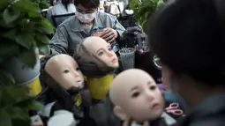 Para pekerja melukis wajah boneka seks di pabrik EXDOLL, sebuah perusahaan yang terletak di Dalian, China, Kamis (1/2). Selain bisa berbicara, boneka seks ini juga bisa bermain musik dan menyalakan mesin pencuci piring. (AFP PHOTO/FRED DUFOUR)