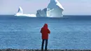 Warga melihat bongkahan es raksasa yang bergerak melewati perairan Ferryland Newfoundland, Kanada, (10/4). Bergeraknya bongkahan es raksasa menarik warga untuk melihatnya. (Paul Daly/The Canadian Press via AP)