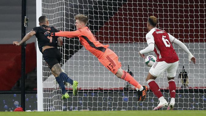 Gelandang Manchester City, Gabriel Jesus (kiri) menyundul bola melewati kiper Arsenal, Runar Alex Runarsson pada laga perempatfinal Piala Liga Inggris di Emirates Stadium, Rabu (23/12/2020) dini hari WIB. Man City ke semifinal Piala Liga Inggris lewat skor 4-1 atas Arsenal. (AP Photo/Frank Augstein)