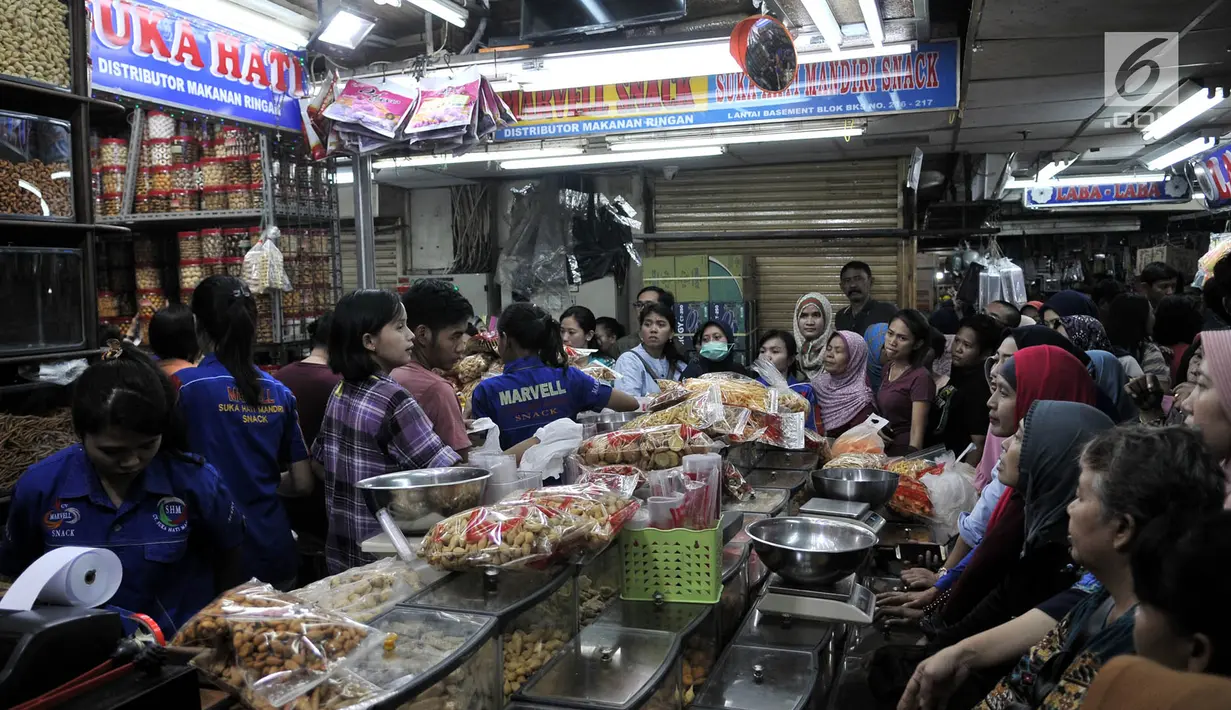 Puluhan pembeli antre untuk mendapatkan kue kering untuk Lebaran di Pasar Jatinegara, Jakarta, Selasa (5/6). Meskipun Idul Fitri masih dua pekan lagi, namun toko kue kering di Pasar Jatinegara mulai diserbu pembeli. (Merdeka.com/ Iqbal S. Nugroho)