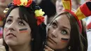 Bandana khas warna bendera Jerman dikenakan para fans cantik ini saat menyaksikan tim kesayangannya melawan Amerika Serikat di sebuah layar raksasa di Berlin pada 26 Juni 2014 (AFP PHOTO/CLEMENS BILAN)