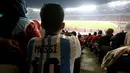 Suporter yang memakai jersey Lionel Messi menyaksikan laga Timnas Indonesia vs Argentina pada FIFA Matchday 2023 di Stadion Utama Gelora Bung Karno, Jakarta, Senin (19/6/2023). (Bola.com/Muhammad Iqbal Ichsan)