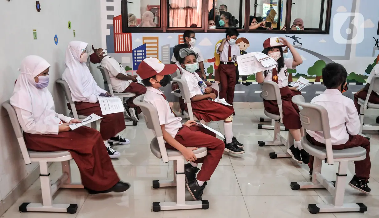 Sejumlah murid duduk menunggu saat observasi usai menjalani vaksinasi COVID-19 di SDN Cempaka Putih Timur 03 Pagi, Jakarta, Selasa (14/12/2021). Pemerintah mulai melakukan vaksinasi COVID-19 kepada anak usia 6-11 tahun. (merdeka.com/Iqbal S. Nugroho)