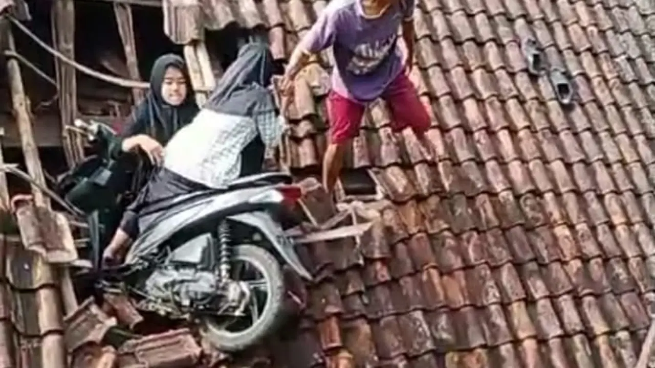 Dua remaja bersama sepeda motor yang mereka gunakan terjebak dipuing puing genteng rumah, sementara satu remaja putri lainya berada dibawah rumah warga, genteng rumah nampak hancur berantakan. (Liputan6.com/Jayadi Supriadin)