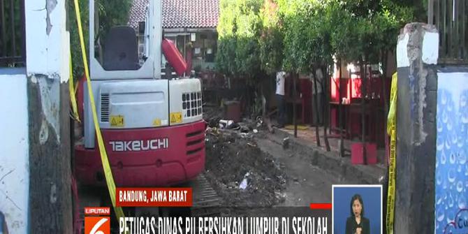 Petugas Bersihkan Sisa Lumpur Banjir yang Rendam Sekolah di Bandung