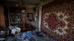 Sebuah foto menunjukkan interior rumah yang hancur, di tengah invasi Rusia ke Ukraina, di desa Vilkhivka, dekat kota timur Kharkiv, pada 14 Mei 2022. Puluhan rumah di Vilkhivka, sebuah desa berpenduduk sekitar 2.000 jiwa, hancur oleh peluru, ledakan atau kebakaran. Puing-puing berserakan di jalan-jalan termasuk selongsong peluru, dan sisa-sisa amunisi. (Dimitar DILKOFF / AFP)