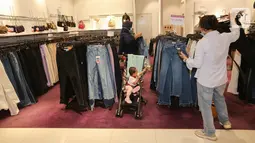 Pengunjung memilih baju pada bazar permanen Red Hot Deals di SOGO departement Store Lippo Mall Puri, Jakarta (24/04/2021). Red Hot Deals  yang berlokasi berlokasi di ground floor memberikan pilihan dan memanjakan pelanggan dengan memberikan diskon hingga 70%  (Liputan6.com/Fery Pradolo)