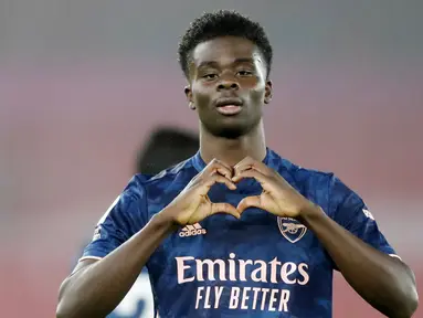 Pemain Arsenal, Bukayo Saka, melakukan selebrasi usai mencetak gol ke gawang Southampton pada laga Liga Inggris di Stadion St Mary, Selasa (26/1/2021). Arsenal menang dengan skor 3-1. (AP/Frank Augstein, Pool)