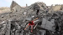 Seorang anak perempuan Palestina mencari jalan di antara reruntuhan bangunan yang dihantam serangan Israel di kamp pengungsi Bureij, Jalur Gaza tengah pada 10 Juli 2025. (Eyad BABA/AFP)