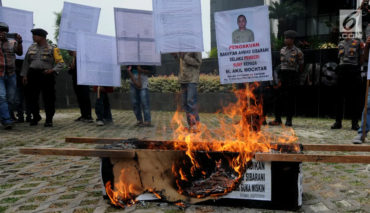 Aktivis Gema Tapteng membakar keranda mayat saat unjukrasa di depan gedung KPK, Jakarta, Rabu (16/5). Mereka mendesak pimpinan KPK segera mengusut sengketa Pilkada Tapanuli Tengah 2011 lalu. (Merdeka.com/Dwi Narwoko)