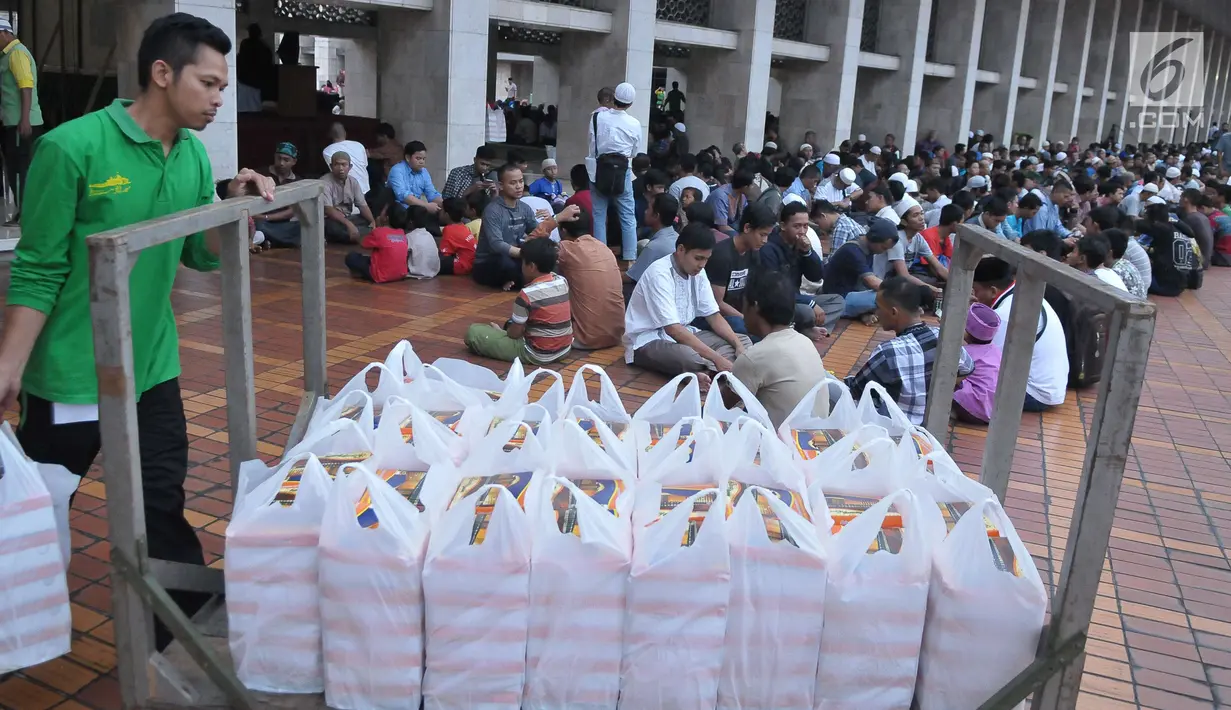 Petugas membagikan takjil jelang berbuka puasa pada hari kedua bulan Ramadan di Masjid Istiqlal, Jakarta, Minggu (28/5). Sebanyak 5000 kotak makanan dibagikan untuk berbuka pada gari Jumat - Minggu. (Liputan6.com/Helmi Afandi) 