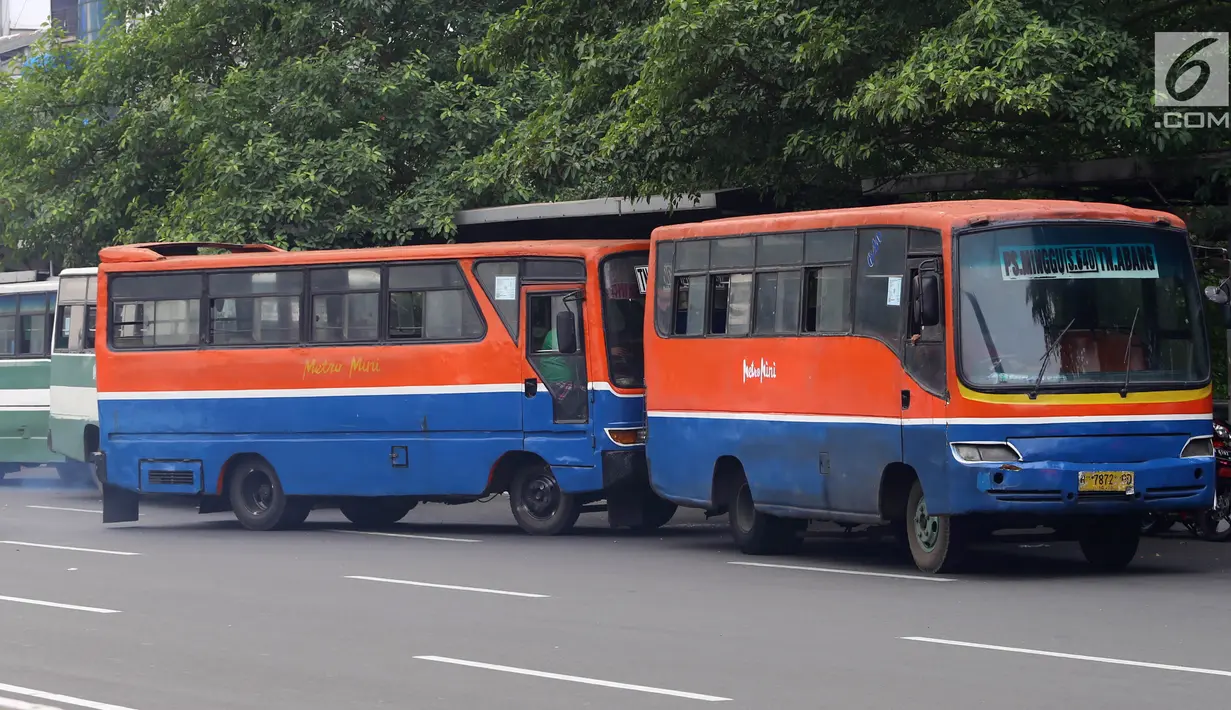 Bus Metromini menunggu penumpang di Jalan Jenderal Sudirman, Jakarta, Rabu (4/7). Larangan bagi Kopaja dan Metromini melintasi jalan protokol selama Asian Games untuk mengurangi kemacetan dan polusi di jalan protokol. (Liputan6.com/Arya Manggala)