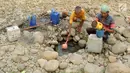 Warga mengambil air pada lubang di aliran Sungai Cipamingkis yang kering, Cibarusah, Bekasi, Jabar, Kamis (2/8). Dua bulan tak diguyur hujan menyebabkan warga perbatasan Bogor-Bekasi dilanda kekeringan dan kesulitan air bersih. (Merdeka.com/Arie Basuki)