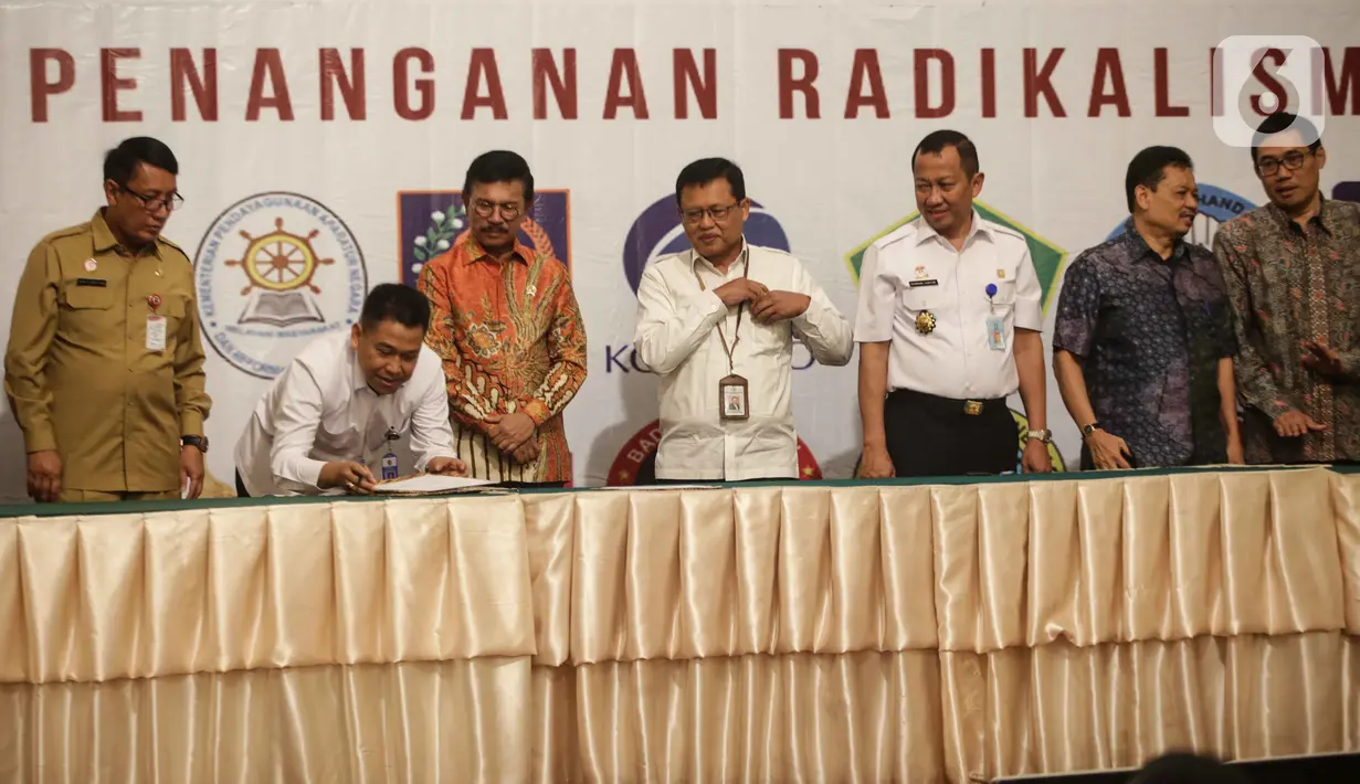 Menkominfo Johnny G. Plate (ketiga kiri) bersama sebelas Kementerian dan lembaga negara  saat penandatangan kerja sama pembuatan portal aduan untuk aparatur sipil negara (ASN), Jakarta, Selasa (12/11/2019). Portal ini bisa melaporkan ASN yang diduga terpapar radikalisme. (Liputan6.com/Faizal Fanani)