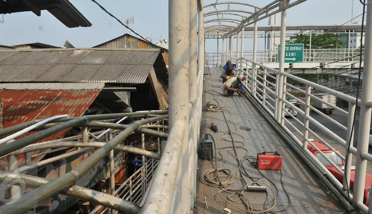 Pekerja menyelesaikan perbaikan Jembatan Penyebrangan Orang (JPO) di Jembatan Asmi, Pulo Gadung, Jakarta, Selasa (3/11/2015). Perbaikan itu dilakukan demi menunjang keselamatan dan kenyamanan pengguna jalan. (Liputan6.com/Gempur M Surya)