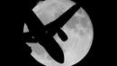 Siluet pesawat pada saat fenomena Supermoon yang muncul di atas langit Ronda, Spanyol, Senin (17/10). Dalam fenomena tersebut, bulan purnama terlihat lebih besar dan terang karena berada di jarak terdekat dengan bumi. (Reuters/Jon Nazca)