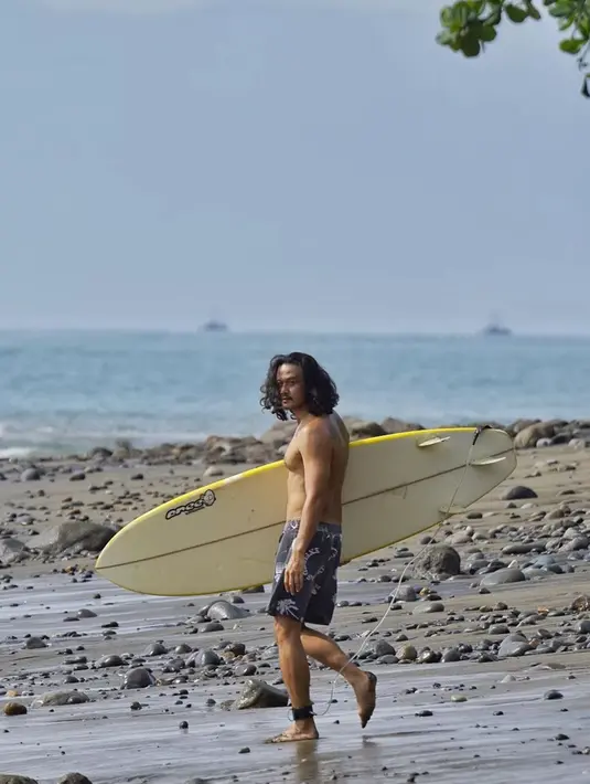 Dwi Sasono juga kerap membagikan potretnya saat melakukan olahraga surfing. Selancar memang salah satu hobinya. Pose dengan tubuh kekar sambil membawa papan selancar membuatnya tak seperti sudah kepala empat. Bintang film Mendadak Dangdut ini tampil cool dan awet muda. (Liputan6.com/IG/@dwisasono)