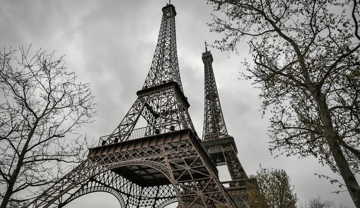 Foto yang diambil pada 1 April 2023 menunjukkan repliqua (kiri) Menara Eiffel, dipasang di dekat yang asli di Paris. (Photo by STEPHANE DE SAKUTIN / AFP)