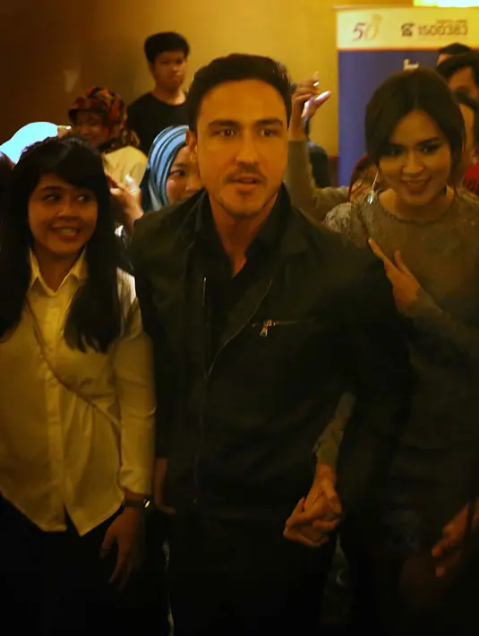 Malam itu keduanya memang tampak serasi. Hamish yang mengenakan jaket kulit hitam berada di samping Raisa dengan gaun berwarna abu-abunya. Pasangan ini terus berjalan berdampingan menyusuri bioskop. (Nurwahyunan/Bintang.com)