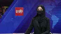 Khatereh Ahmadi, seorang presenter TOLO News di Kabul, Afghanistan hari Minggu (22/5/2022) mengudara dengan wajah tertutup. (AP)