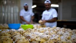 Tukang roti menyiapkan adonan untuk membuat Bolo Rei atau Kue Raja di toko roti Padaria da Ne, Amadora, Portugal, 16 Desember 2022. National Association of Bread and Pastry Producers memberikan hadiah tahunan untuk Bolo Rei terbaik di Portugal. (CARLOS COSTA/AFP)