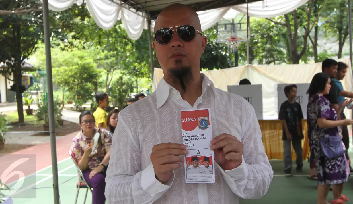 Musisi Ahmad Dhani menunjukan surat suara jelang mencoblos di TPS 024 Pondok Pinang, Jakarta, Rabu (19/4).  Dhani secara terbuka sampaikan pilih Anies Baswedan yang berpasangan dengan Sandiaga Uno. (Liputan6.com/Herman Zakharia)