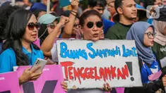 Mantan Menteri Kelautan dan Perikanan Susi Pudjiastuti membawa poster saat mengikuti pawai bebas plastik di kawasan Sudirman, Jakarta, Minggu (30/7/2023). (Liputan6.com/Faizal Fanani)