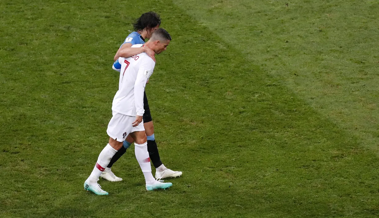 Penyerang Portugal, Cristiano Ronaldo memapah Penyerang Uruguay, Edinson Cavani yang Cedera saat babak 16 besar Piala Dunia 2018 di Stadion Fisht di Sochi, Rusia (30/6). Pada saat itu Uruguay unggul 2-1 atas Portugal. (AP Photo/Darko Vojinovic)
