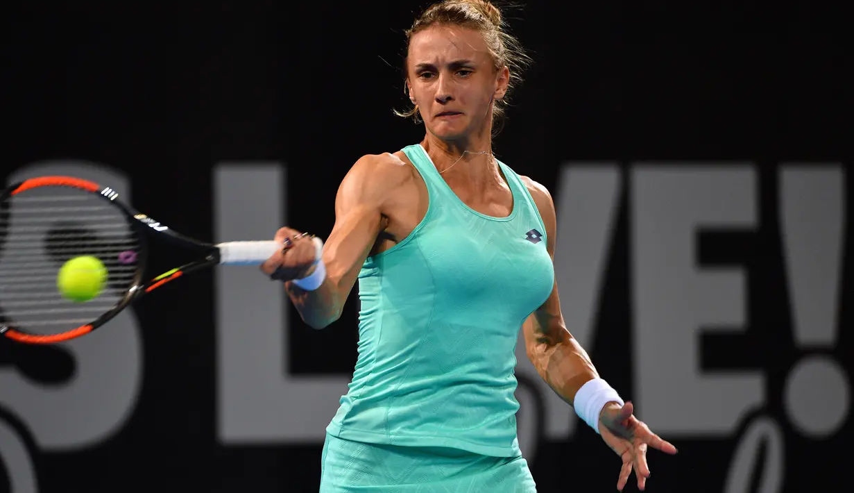 Petenis dari Ukraina, Lesia Tsurenko memukul bola saat melawan petenis Australia Ashleigh Barty pada pertandingan putaran pertama turnamen tenis Brisbane International di Brisbane (1/1). (AFP Photo/Saeed Khan)