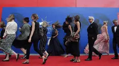 Sejumlah selebriti tertiup angin saat berjalan menghadiri "Penghargaan Franca Sozzani" selama Festival Film Venice ke-74 di Venice Lido (1/9). (AFP Photo/Tizianaa Fabi)