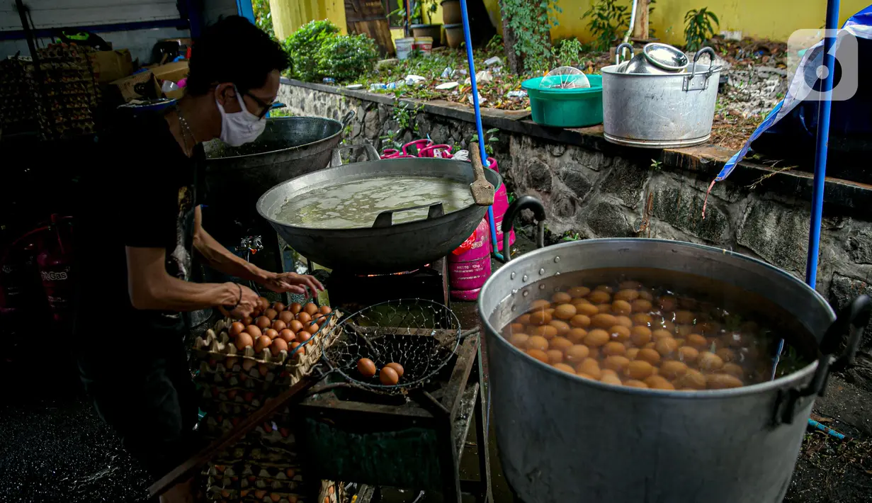 Petugas Taruna Siaga Bencana (Tagana) merebus telur di Dapur Umum Kementerian Sosial di GOR Otista, Jakarta, Minggu (21/2/2021). Dalam sehari, petugas menyiapkan hingga 6.000 paket nasi kotak yang didistribusikan ke 11 kelurahan terdampak banjir. (Liputan6.com/Faizal Fanani)