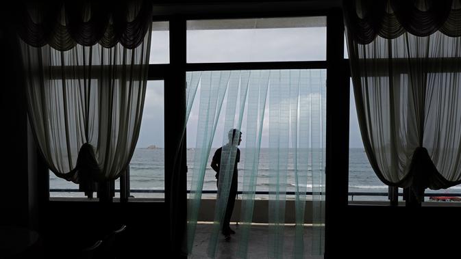 Seorang pria menikmati suasana pantai Sijung Ho di luar sebuah restoran di Korea Utara Utara (14/7/2019). Pantai Sijung Ho merupakan tujuan wisata populer bagi penduduk lokal dan asing. (AP Photo/Vincent Yu)