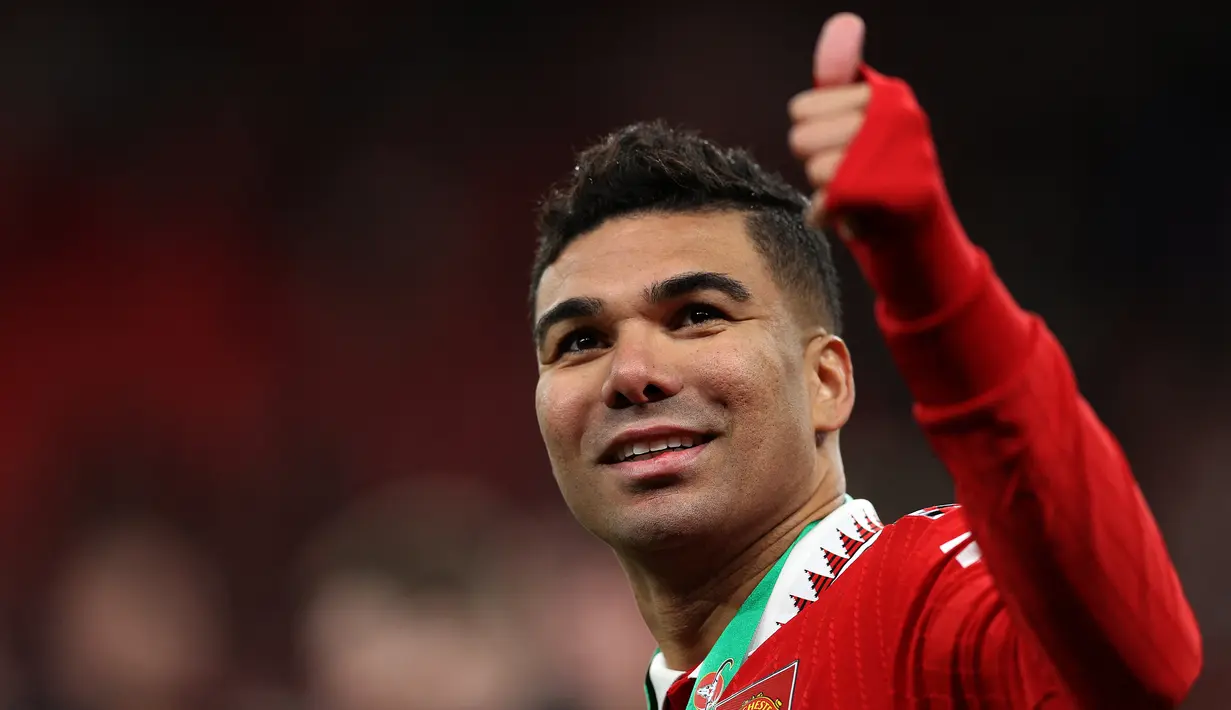 Gelandang Manchester United,Casemiro memberi isyarat kepada para pendukung selama perayaan juara Carabao Cup 2022/2023 mengalahkan Newcastle United pada laga final di Stadion Wembley di London, Senin dini hari WIB (27/2/2023). Kemenangan ini menuntun MU jadi juara EFL Cup/Carabao Cup 2022-2023. Trofi pertama di era Ten Hag. (AFP/GLYN KIRK)