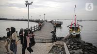 Pengujung berwisata di Pantai Ancol, Jakarta, Rabu (28/12/2022). Isu cuaca yang kurang bersahabat pada hari ini, tidak menyurutkan keinginan warga menghabiskan libur untuk berwisata di kawasan wisata Ancol. (Liputan6.com/Faizal Fanani)