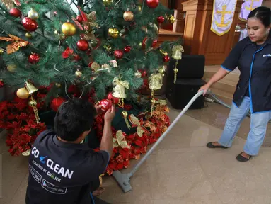 Petugas GO-CLEAN membersihkan pohon natal di GPIB Effatha di kawasan Melawai Jakarta Selatan, Rabu (21/12). Kegiatan ini merupakan rangkaian dari program #NatalanNyaman Bersama GO-CLEAN. (Liputan6.com/Fery Pradolo)