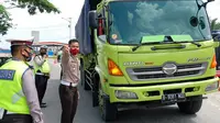Polisi mengecek kendaraan masuk di posko perbatasan Covid-19 di Riau untuk mencegah lonjakan virus corona. (Liputan6.com/M Syukur)