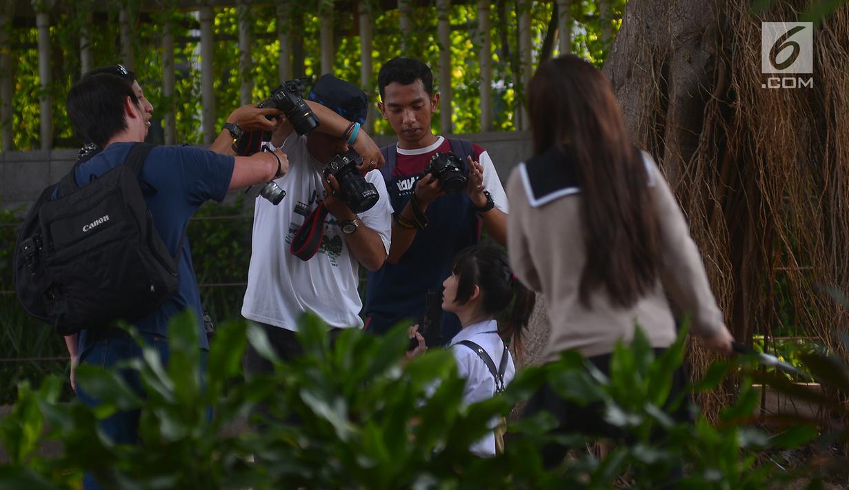 Sejumlah fotografer melakukan sesi foto model di kawasan Bundaran HI,Jakarta, Sabtu (16/6). Di hari kedua lebaran fotografer memanfaatkan jalan kosong untuk hunting model bersama. (Merdeka.com/Imam Buhori)