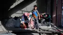 Seorang anak pengungsi Palestina berdiri di dalam rumah yang menjadi sasaran serangan Israel di kamp pengungsi Maghazi, Jalur Gaza Tengah pada Kamis 21 Mei 2026. (Eyad Baba/AFP)